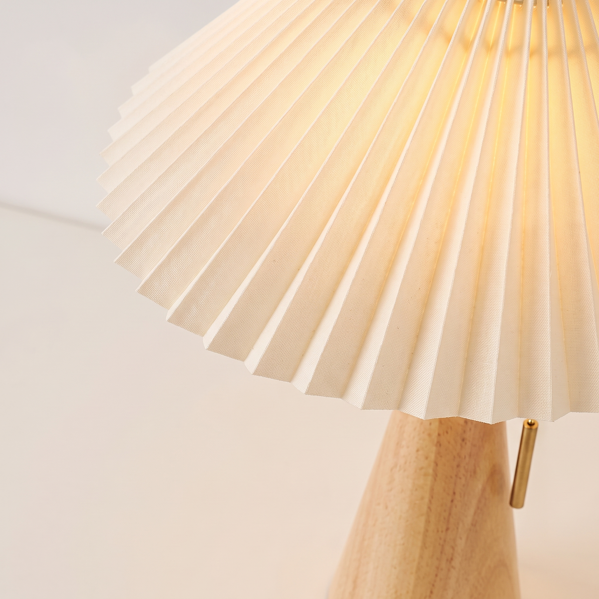 Pleated cream lamp shade seen from above showing the fan of knife pleats and the zigzag hem