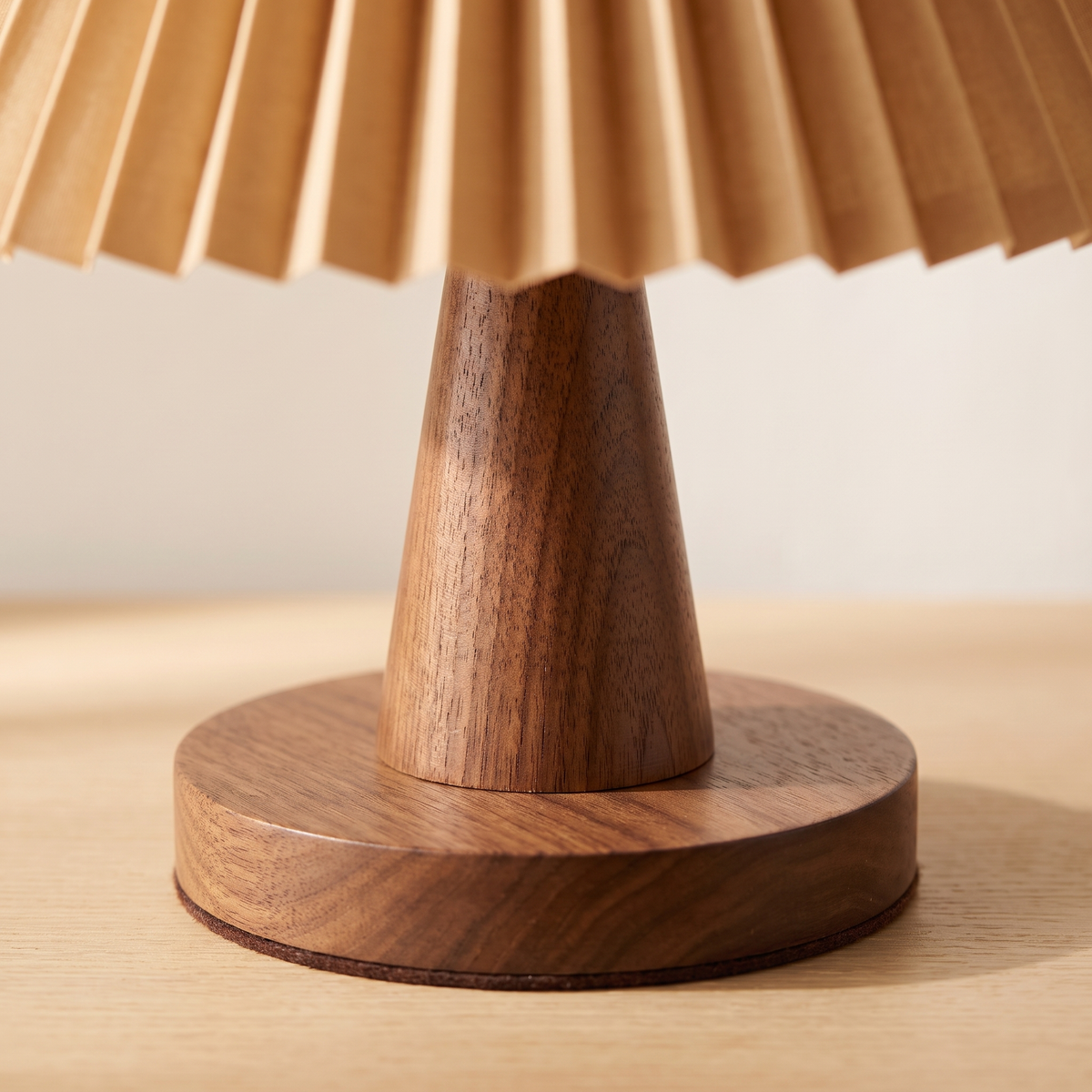 Close up of the walnut cone base showing the turned wood grain and the wide circular foot