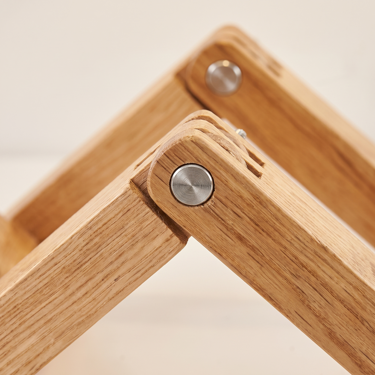 Close up of the hinged wooden joints and the small silver pivot screws in the lamp body