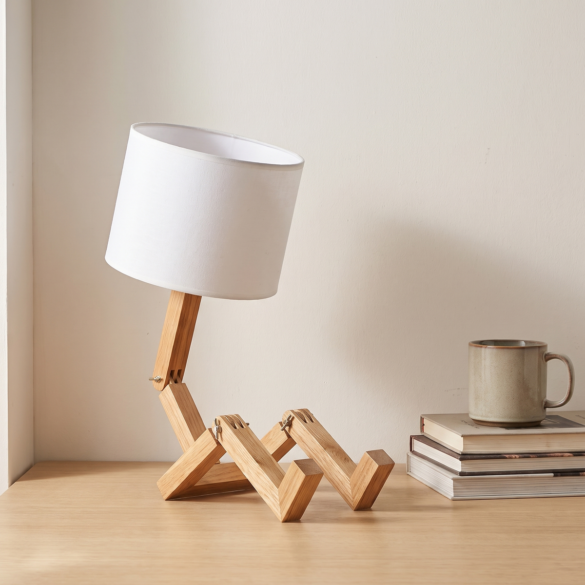 Jointed wooden robot desk lamp beside a stack of books and a mug showing its 44cm height