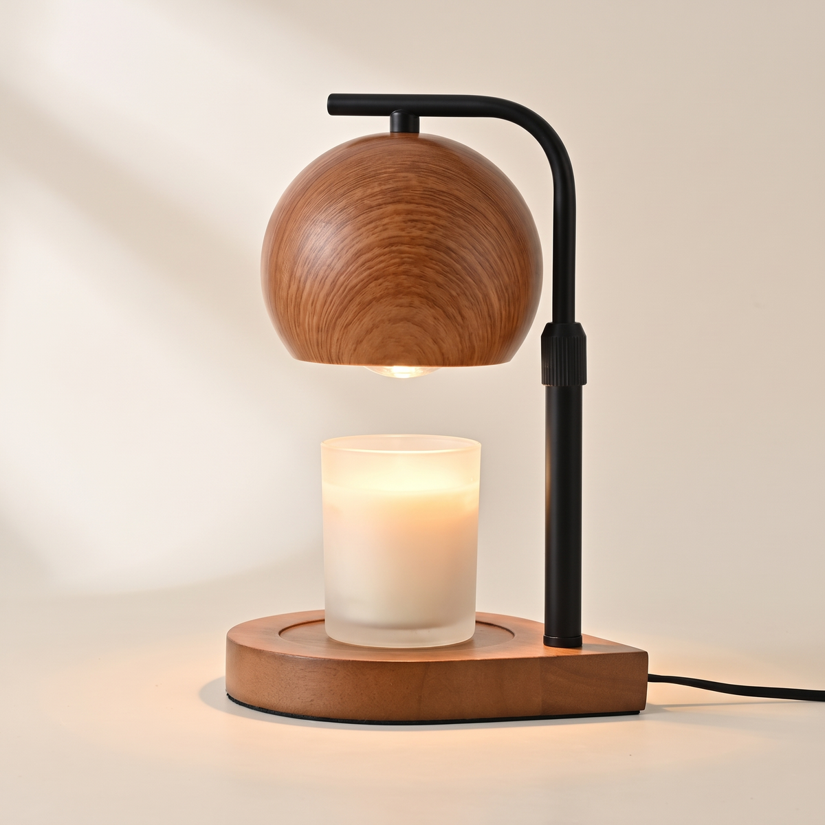 Walnut candle warmer lamp with a black arm warming a jar candle from above, switched on