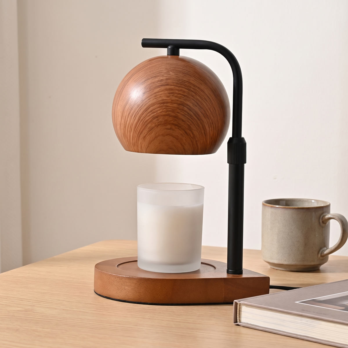 Walnut candle warmer lamp beside a book and a mug showing its size