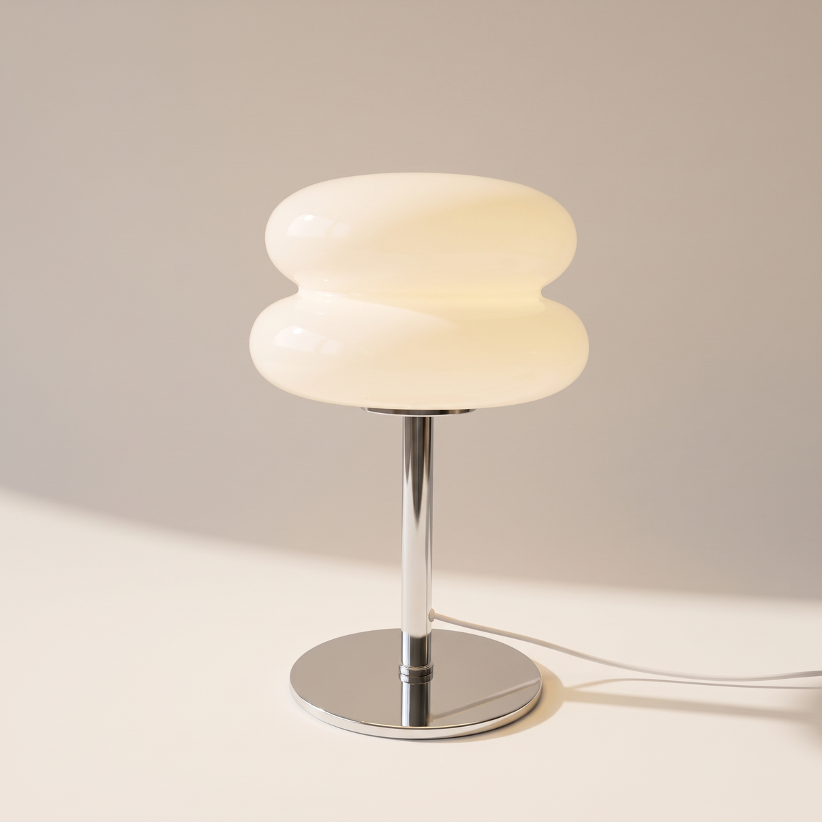 White macaron glass table lamp with two stacked tiers on a chrome stem, switched on