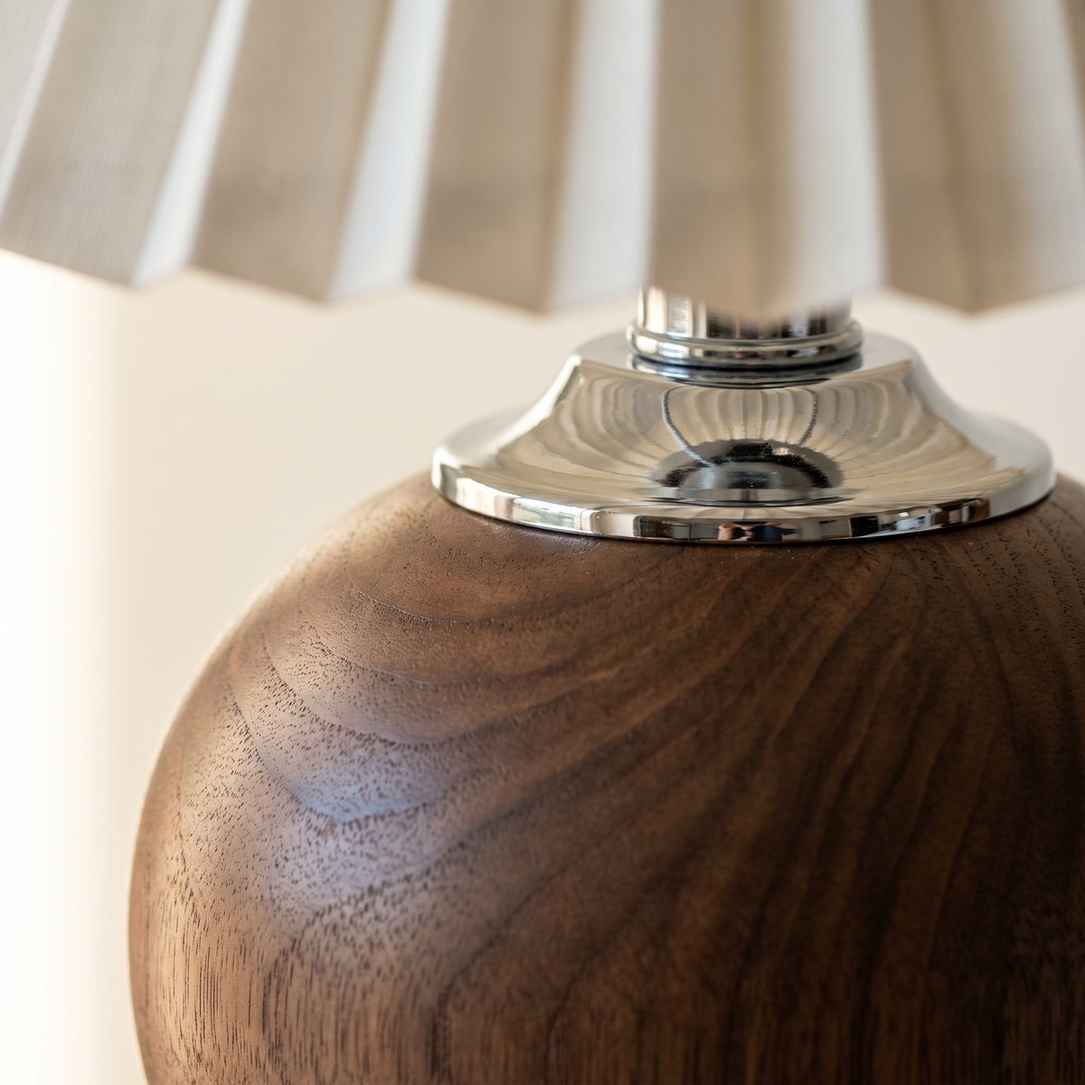 Close up of the chrome collar seated on the turned wooden ball base
