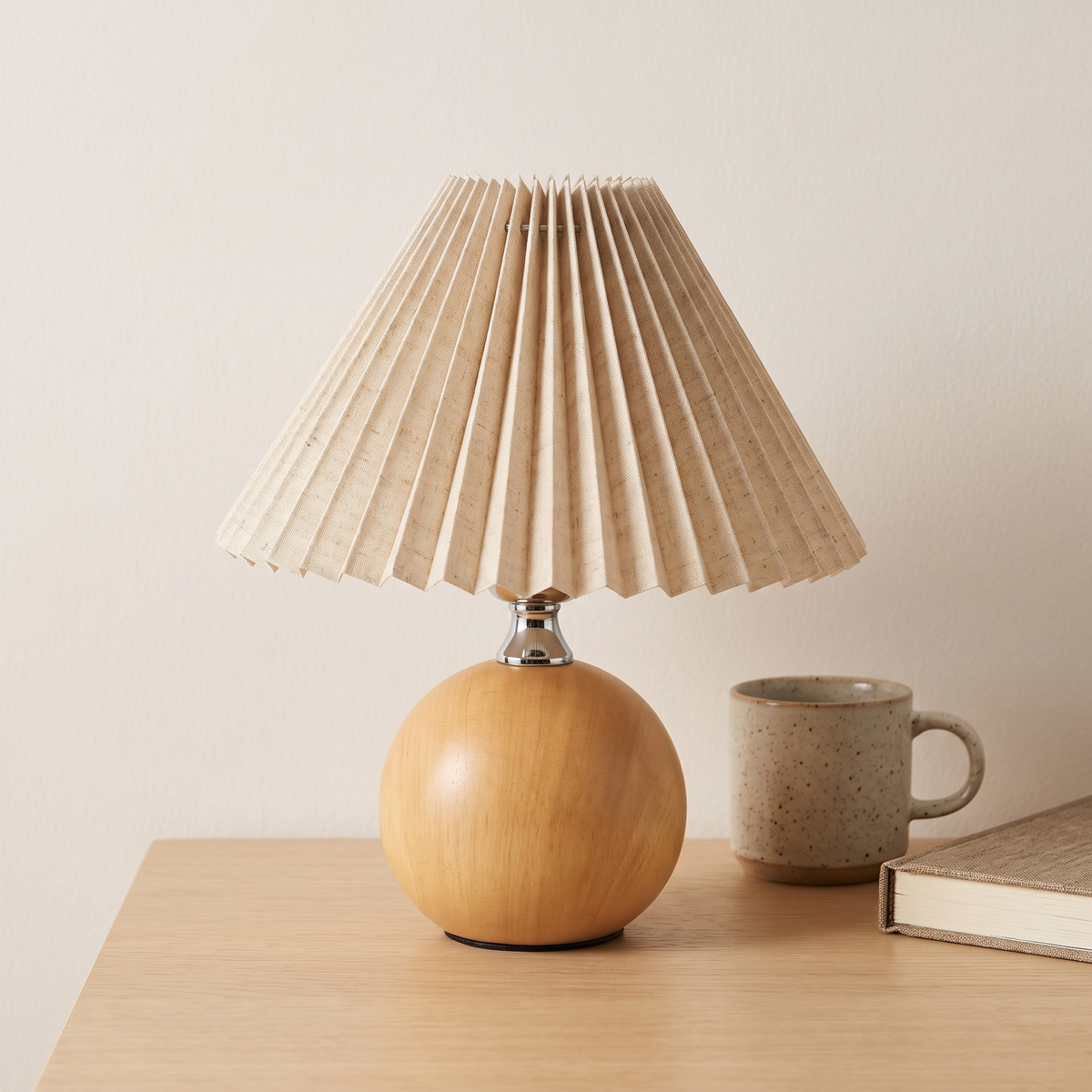 Small wooden ball table lamp beside a mug and a book showing how small it is