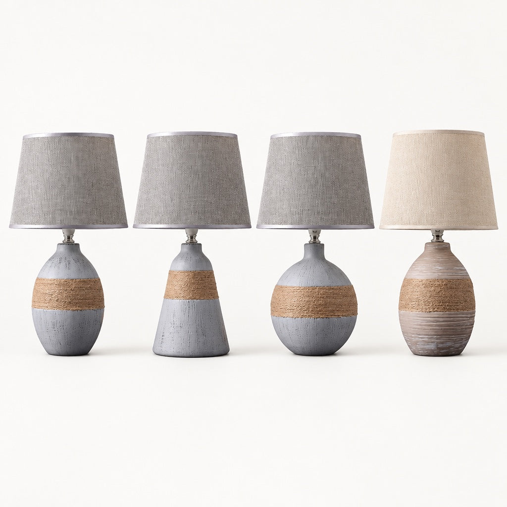 Four ceramic table lamps in a row showing the egg, bell and sphere shapes in grey and the egg in taupe