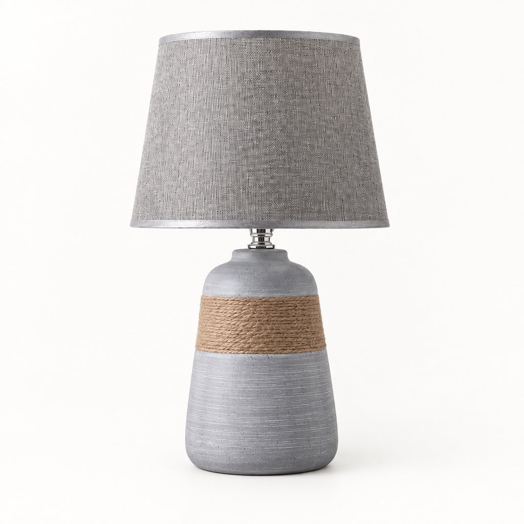 Grey bell-shaped ceramic table lamp flaring to a wide base with a rope band and a grey linen shade