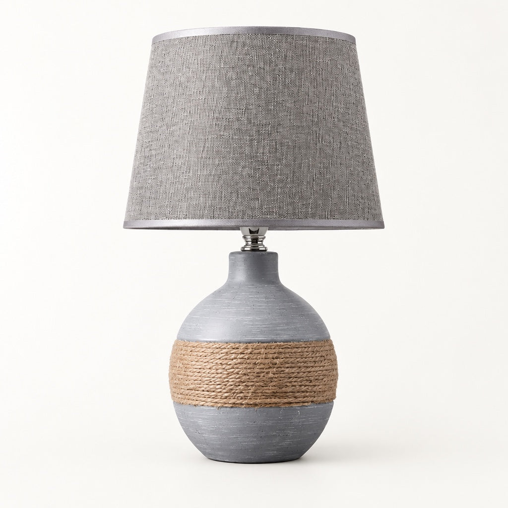 Grey sphere-shaped ceramic table lamp with a rope band around the middle and a grey linen shade